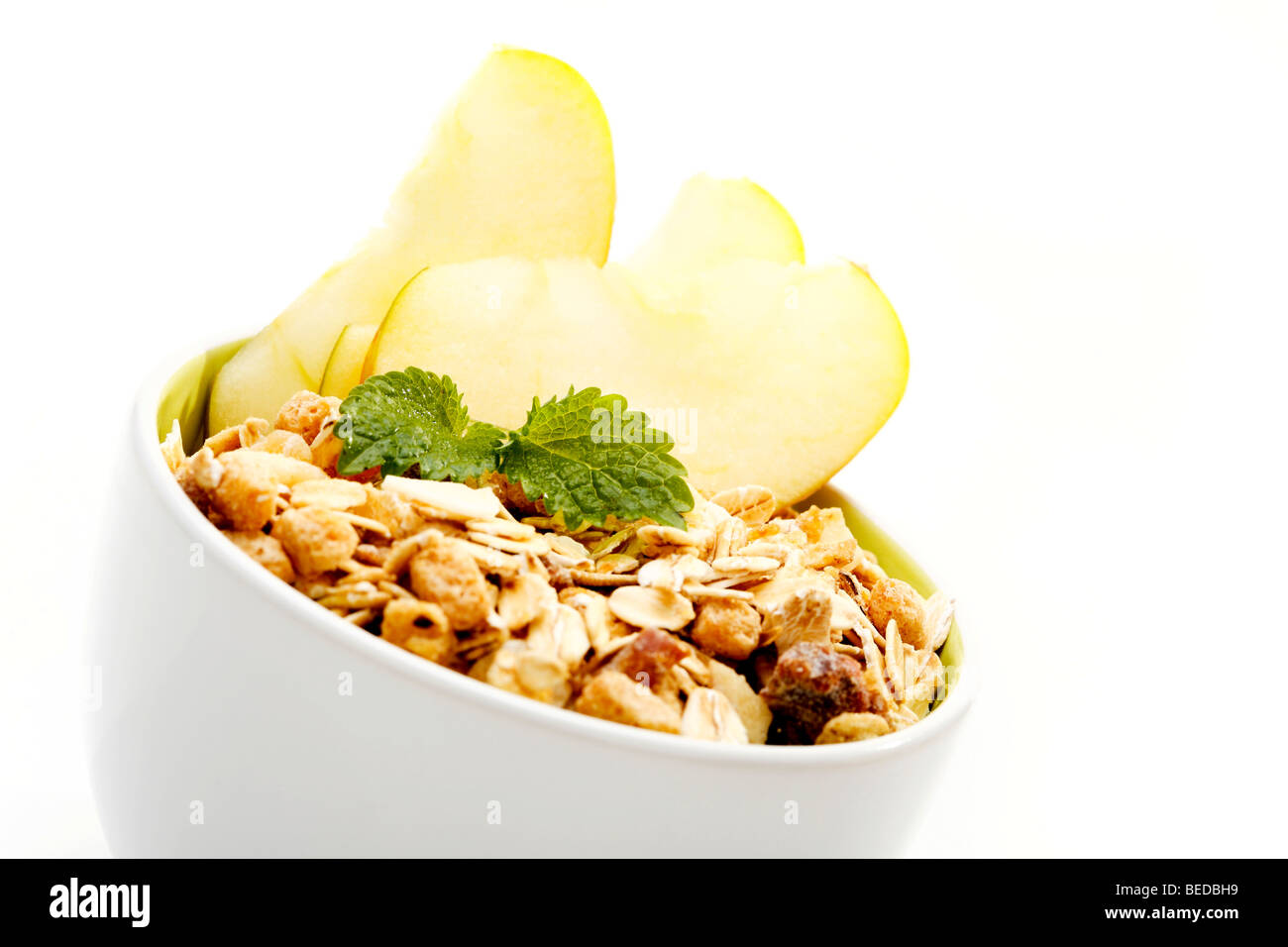 Früchte-Müsli und Äpfel in eine Schüssel geben Stockfoto