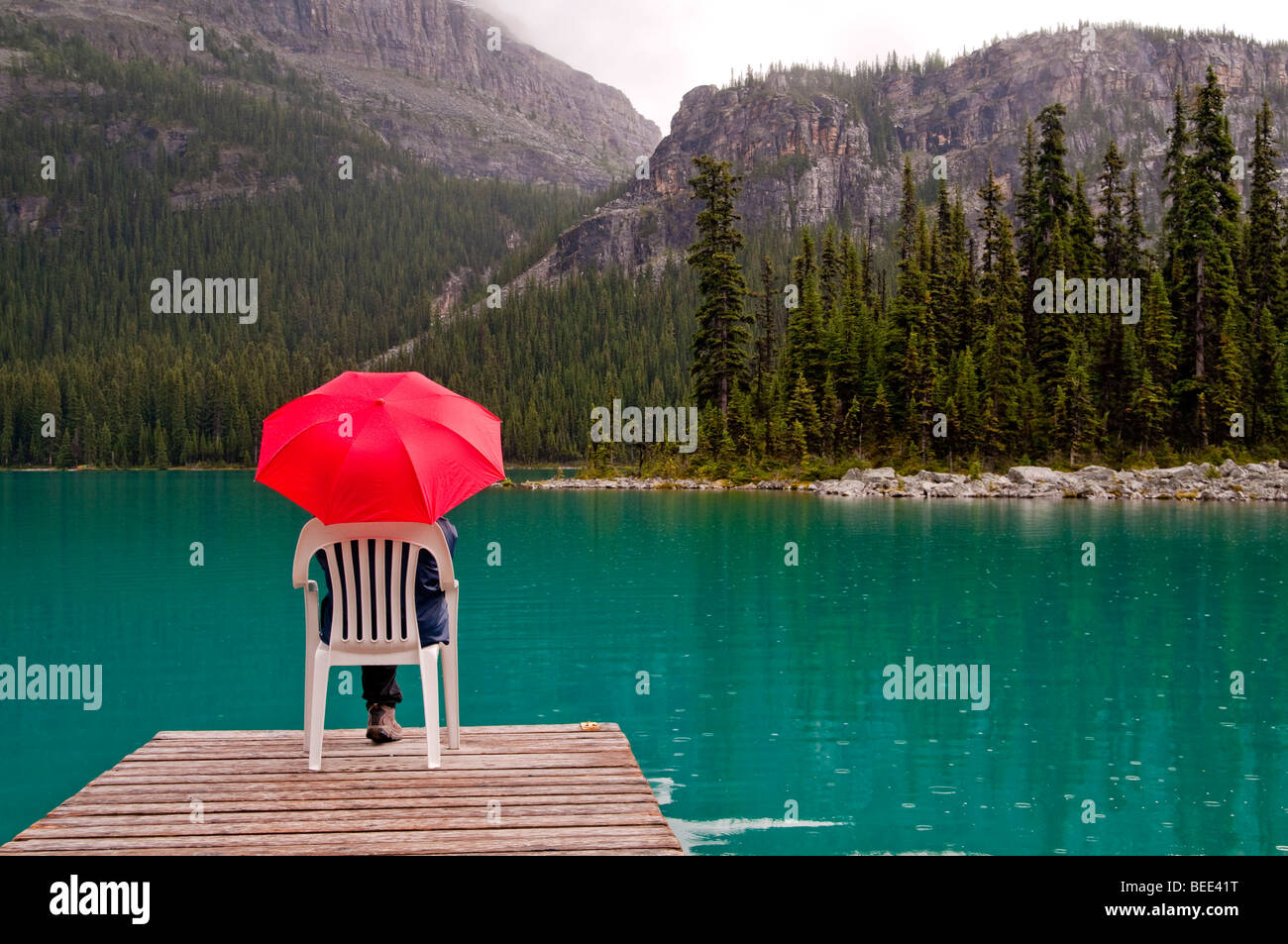 roten Regenschirm mit smaragdgrünen Seewasser und dock Stockfoto