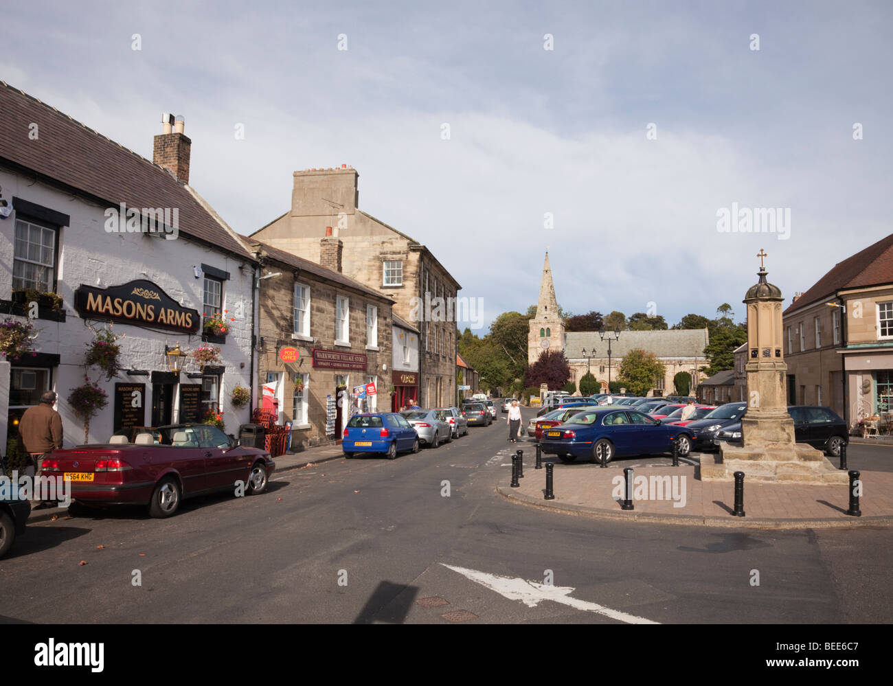 Warkworth, Northumberland, England, Vereinigtes Königreich, Europa. Geschäftigen Ortskern mit parkenden Autos und Markt Kreuz Stockfoto