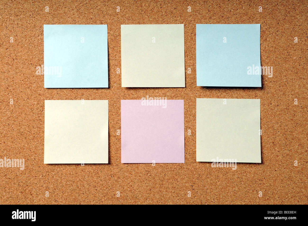 Selbstklebende Notizblöcke in verschiedenen Farben auf einer Pinnwand Stockfoto