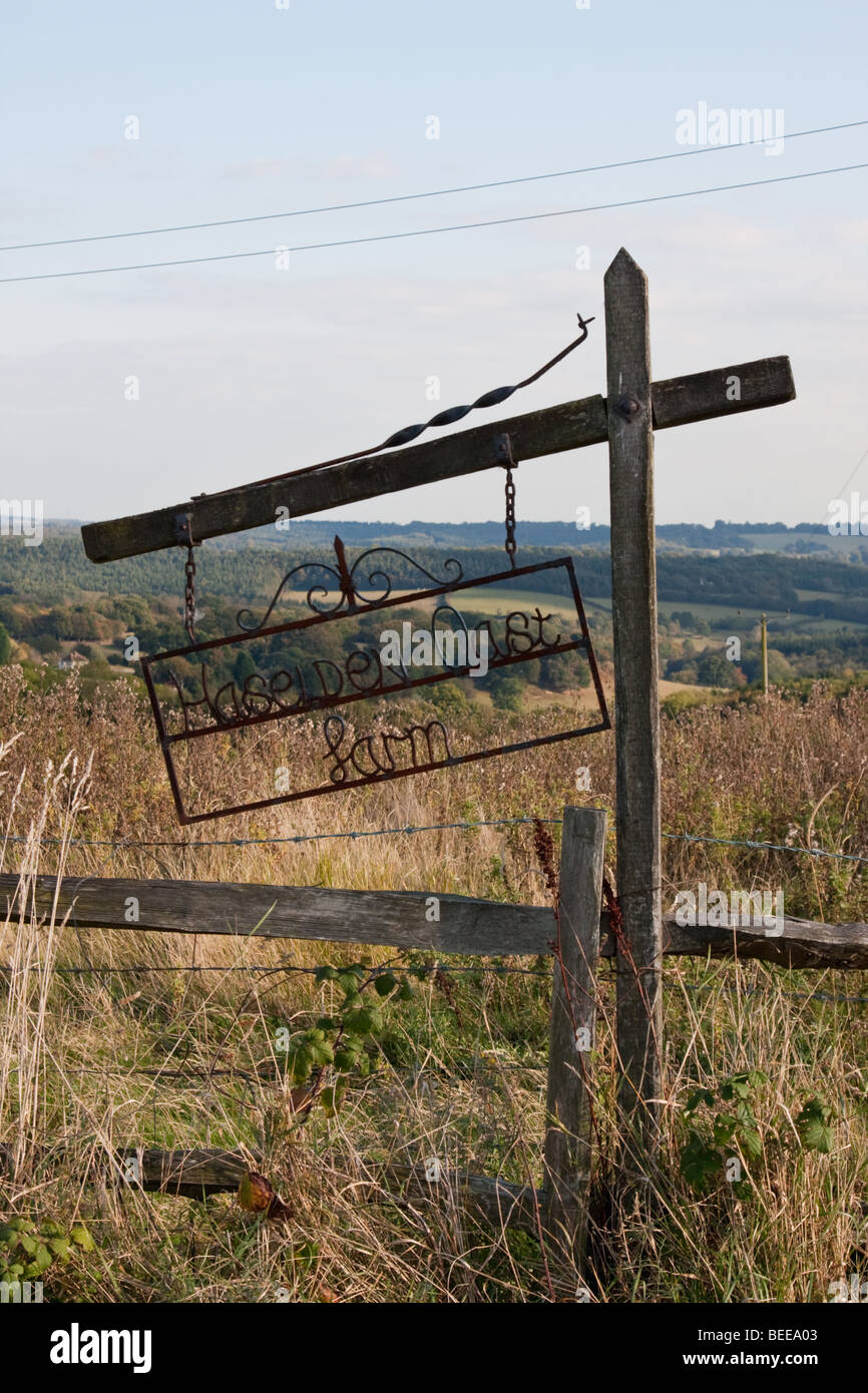 Alte rostige Schild mit Haselden Oast Farm, im Herbst gegen Sussex Hügel abgebildet. Stockfoto