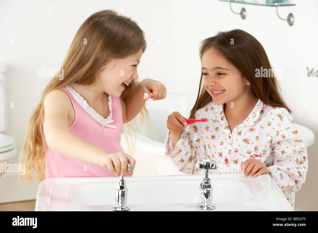 Zwei junge Mädchen Zähneputzen am Waschbecken Stockfoto