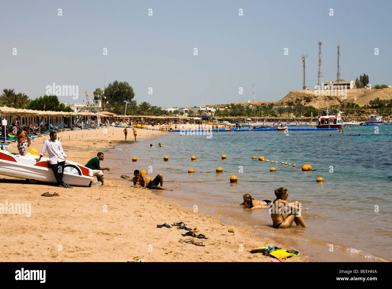 Touristen genießen die Sonne am Strand von Naama Bay, Sharm el Sheikh, Rotes Meer, Ägypten Stockfoto