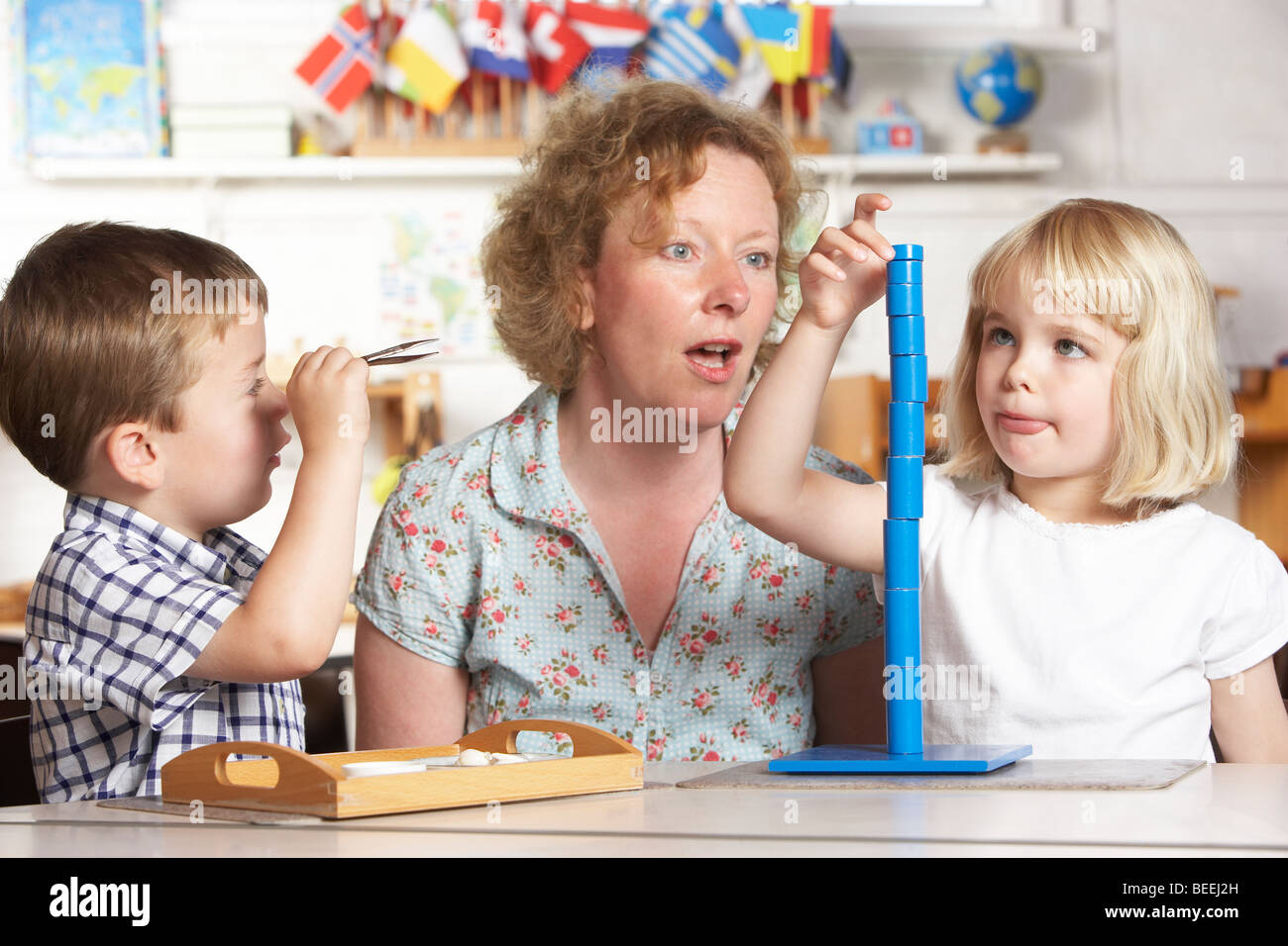 Erwachsenen helfen zwei kleine Kinder im Montessori/Pre-School Stockfoto