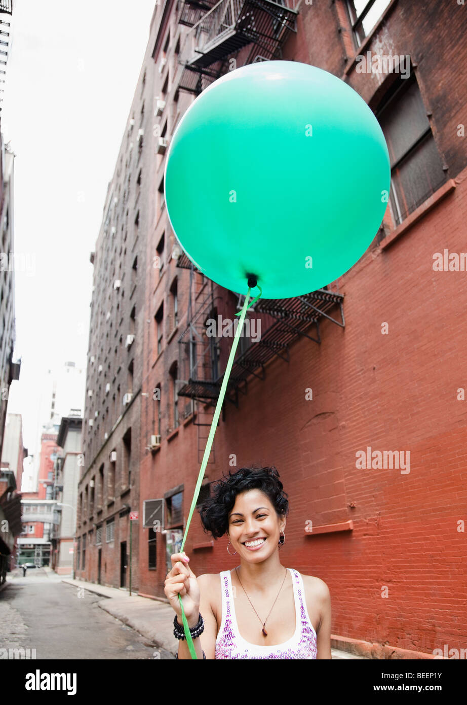 Gemischte Rassen Frau mit Ballon auf städtischen Straße Stockfoto