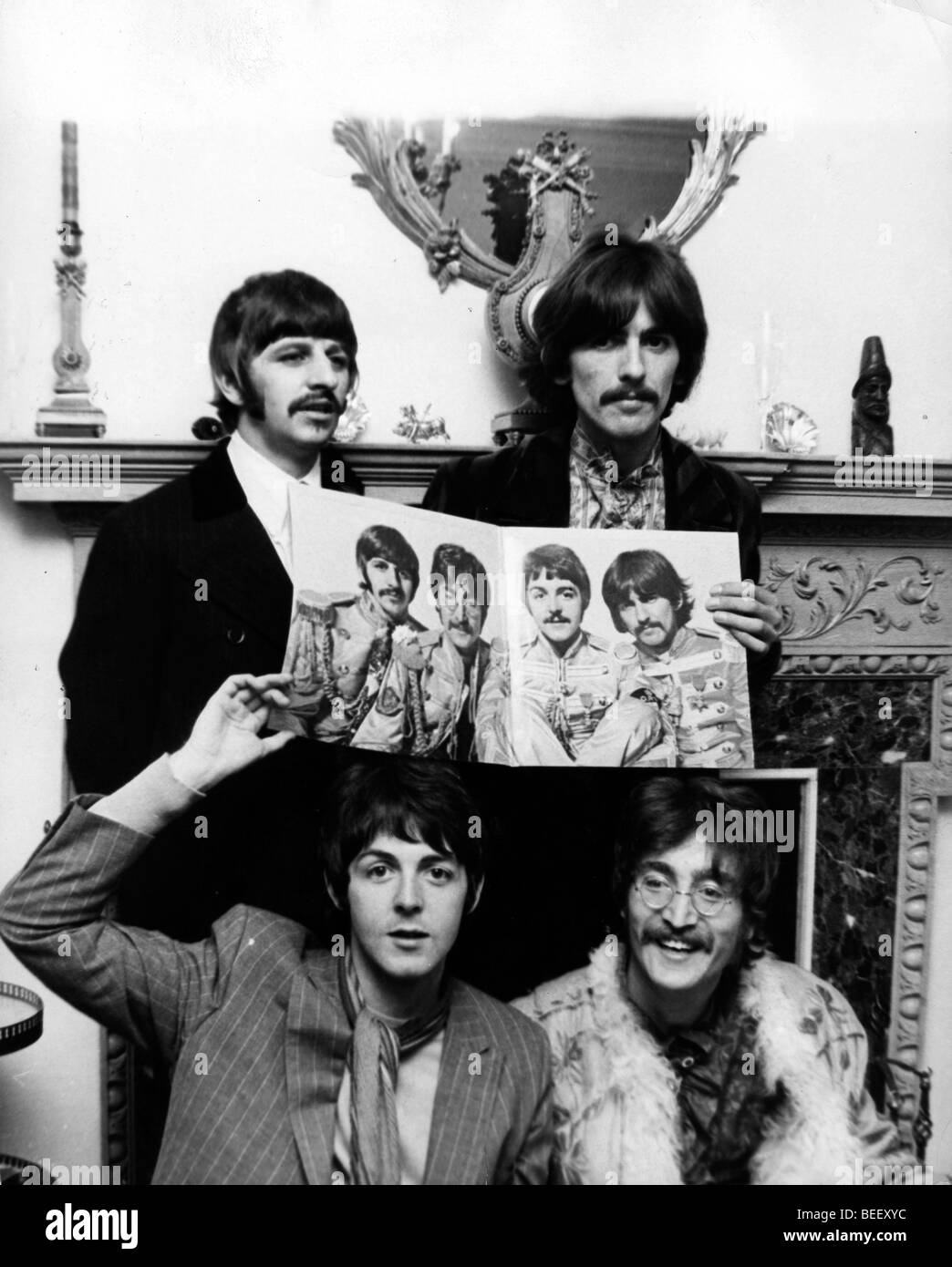 (L-R) Beatles Ringo Starr, Paul McCartney, George Harrison und John Lennon hält ein Foto von sich aus Sgt. Pepper. Stockfoto