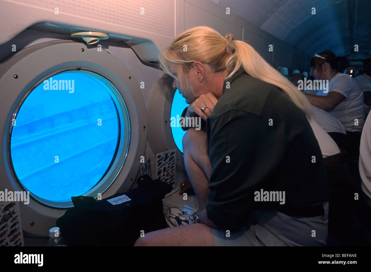 In der Atlantis u-Boot, Frau auf der Suche durch Bullauge an einem alten Schiffswrack, Grand Cayman, Karibik Stockfoto