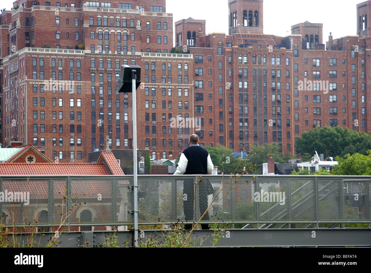 Mann, Blick auf Gebäude in Manhattan auf der hohen Linie Gehweg über den Meatpacking District, New York City, USA Stockfoto