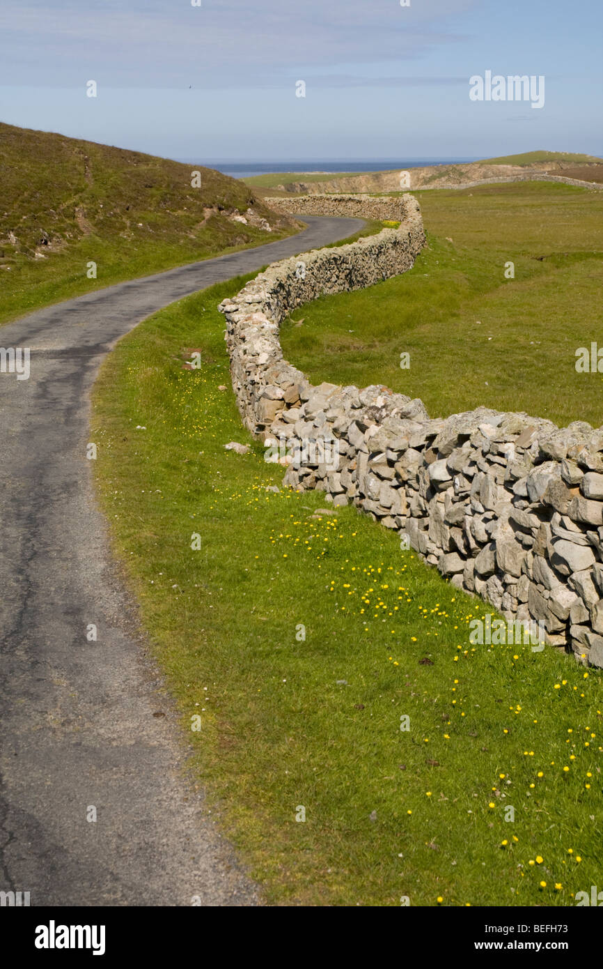 Leere Straße mit Trockenmauer auf Fair Isle Shetland Stockfoto