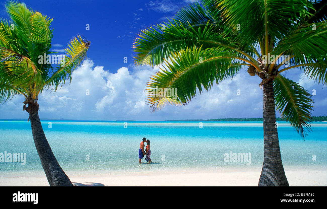 Paar küssen unter Palmen auf One Foot Island in der Nähe von Aitutaki, Cook-Inseln Stockfoto