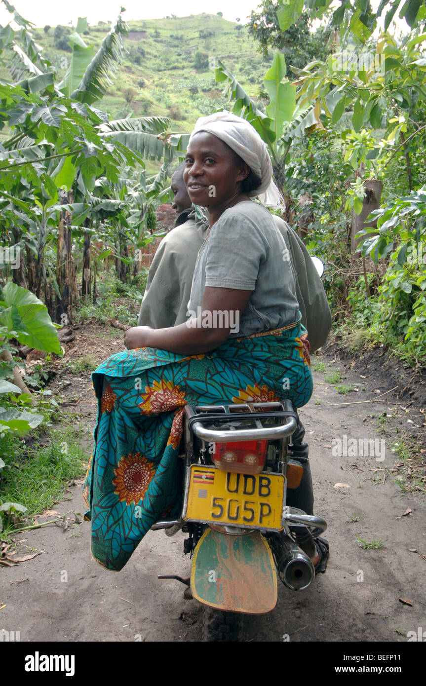 Bakonzo Frau Reiten seitwärts auf Rückseite Taxi Fahrrad, Ruwenzori-Gebirge, West-Uganda, Afrika Stockfoto