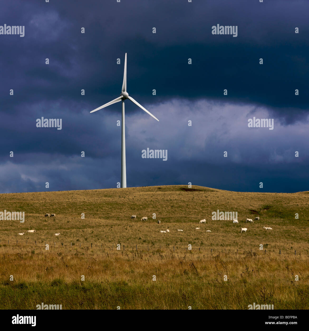 Große Windkraftanlage auf einem Plateau in einer ländlichen Umgebung mit dunklen Gewitterhimmel Stockfoto