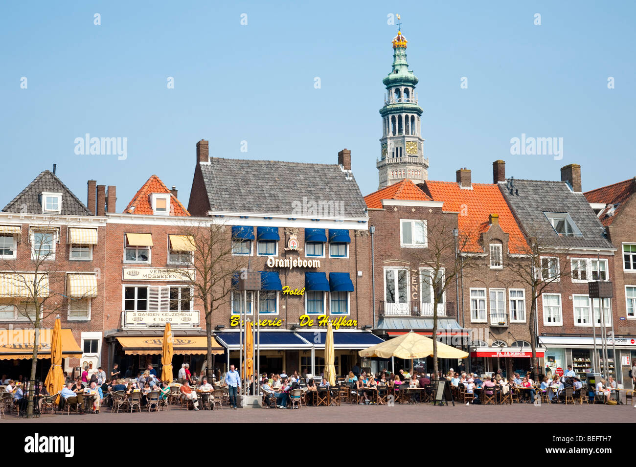 Wohnhäuser auf dem Marktplatz stehen vor Lange Jan (Long Johns), der Turm der Abtei, in Middelburg / Holland Stockfoto