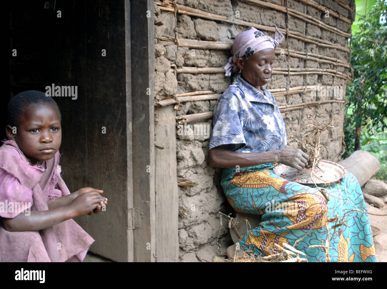 Bakonzo Frau vorbereiten Bohnen mit Enkelin, Ruwenzori-Gebirge, West-Uganda, Afrika Stockfoto