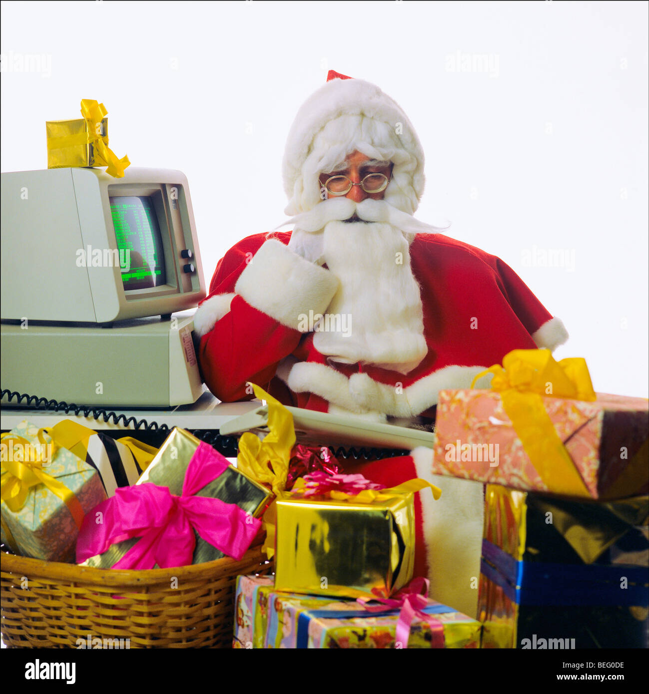 Santa Claus mit 1980er IBM personal computer und Weihnachtsgeschenke Stockfoto