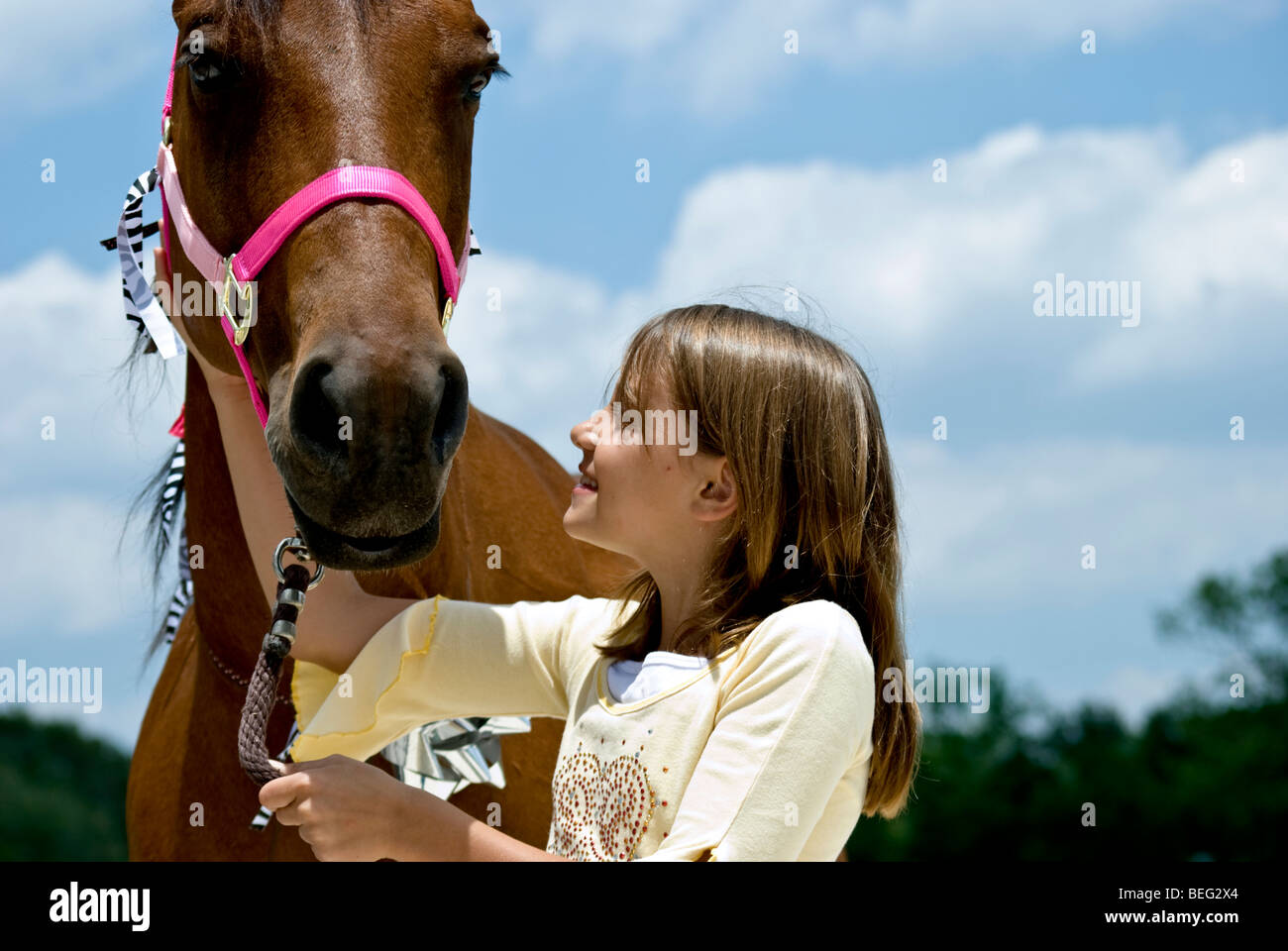 Ein kleines Mädchen, voller Vorfreude auf ein Pferd sucht, die ihr zum Geburtstag geschenkt worden ist. Stockfoto