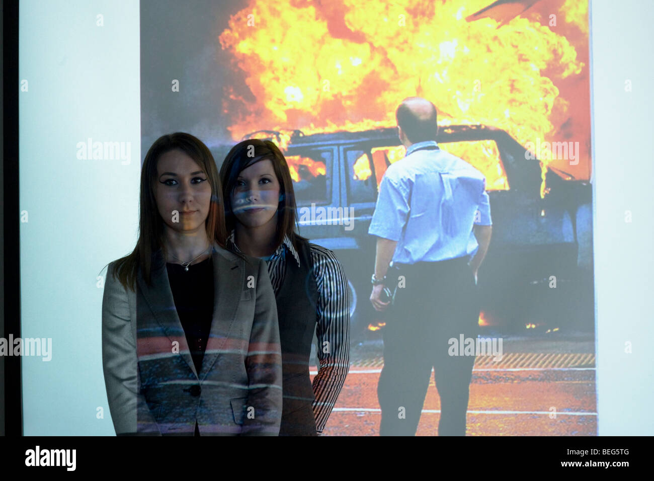 Zwei weibliche BAA Sicherheit Instruktoren stehen vor einer Powerpoint Darstellung der Glasgow Flughafen Terroranschlag. Stockfoto
