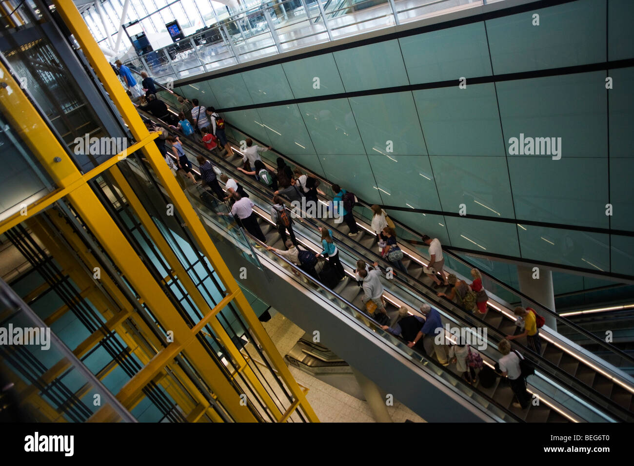 Ankommende Passagiere auf Rolltreppe und Flughafen Architektur am Heathrow Terminal 5. Stockfoto