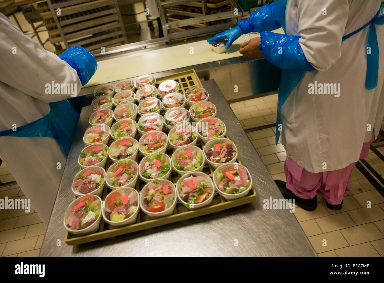 Weibliche Mitarbeiter bereitet Salate von Gate Gourmet am Flughafen Heathrow für Airline Mahlzeiten bestimmt. Stockfoto