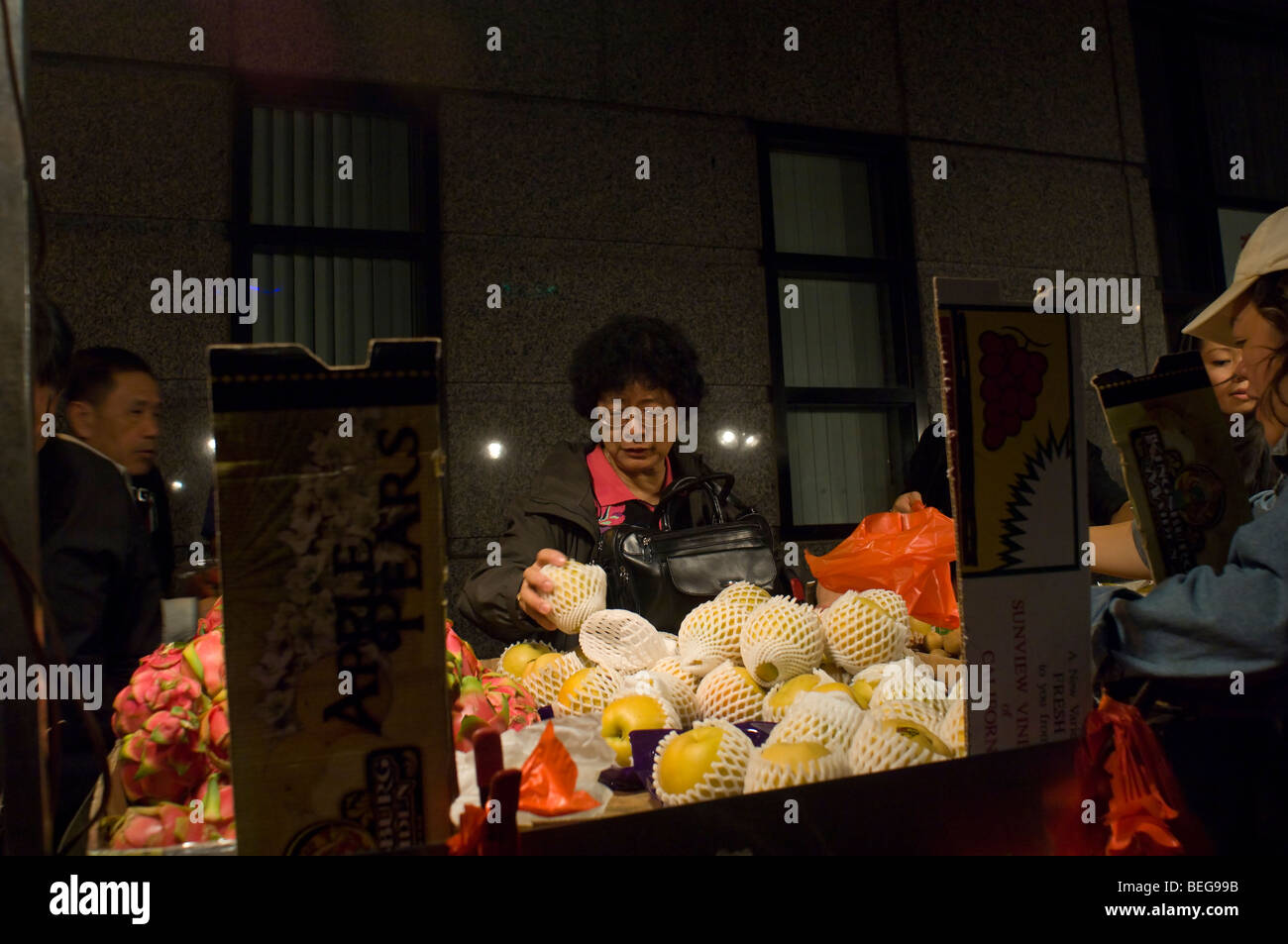 Eine Frau kauft Obst von einem chinesischen Frucht Hausierer in Chinatown in New York auf Sonntag, 4. Oktober 2009. (© Frances M. Roberts) Stockfoto