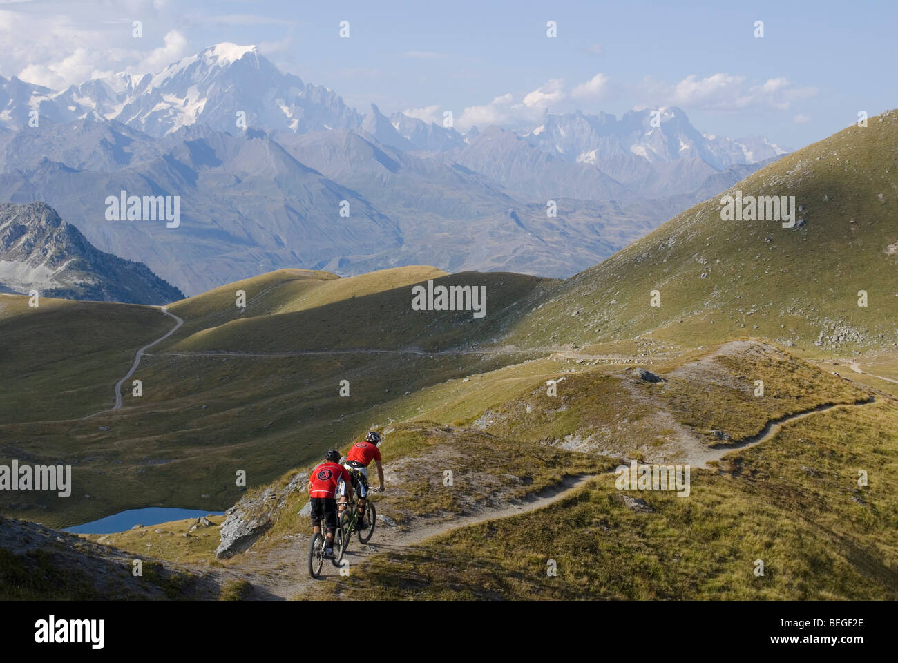Zwei Mountainbiker fahren ein Singletrack Trail in Les Arcs in den französischen Alpen mit dem Mont Blanc im Hintergrund. Stockfoto
