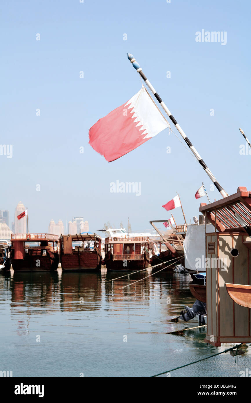 Ein Blick auf die Dhau-Hafen in Doha, Katar, mit dem Fokus auf Katar Nationalflagge. Stockfoto