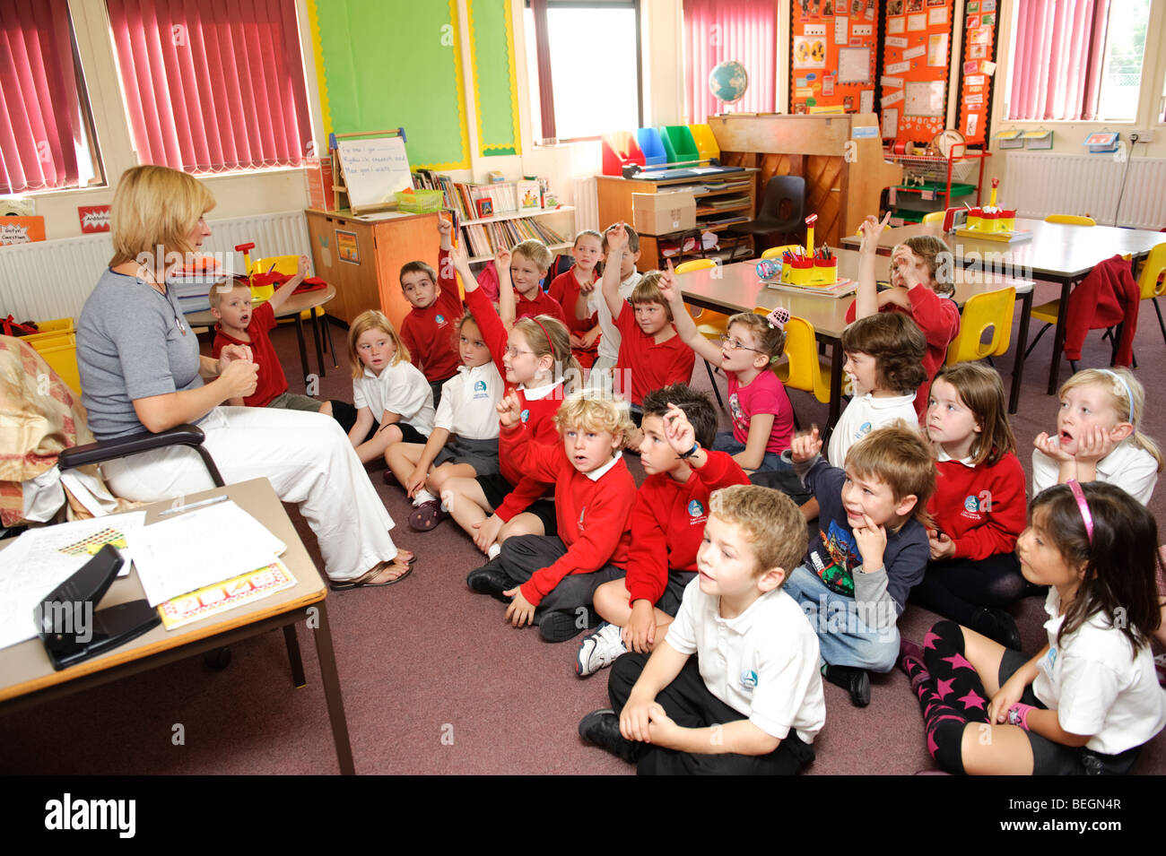 Frau Lehrer im Gespräch mit ihren Kindern Jahr 3 (wichtige Stufe eins) in einer walisischen Sprache mittlere Grundschule, Wales UK Stockfoto
