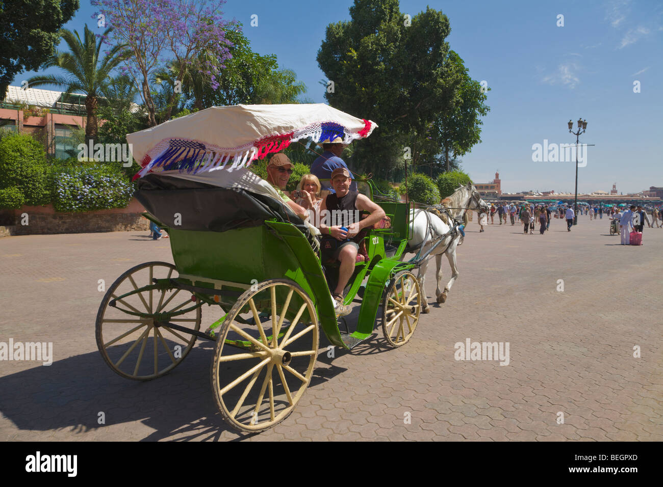 Touristen in einem Pferd gezogenen Wagen und Platz Djemma el Fna Marrakesch Marokko Stockfoto