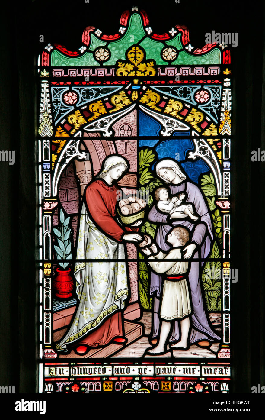 Ein Buntglasfenster, das einen korporalen Akt der Barmherzigkeit (füttern Sie die hungrigen) von Frederick Preedy, Church of St Mary the Virgin, Gunthorpe, Norfolk darstellt Stockfoto
