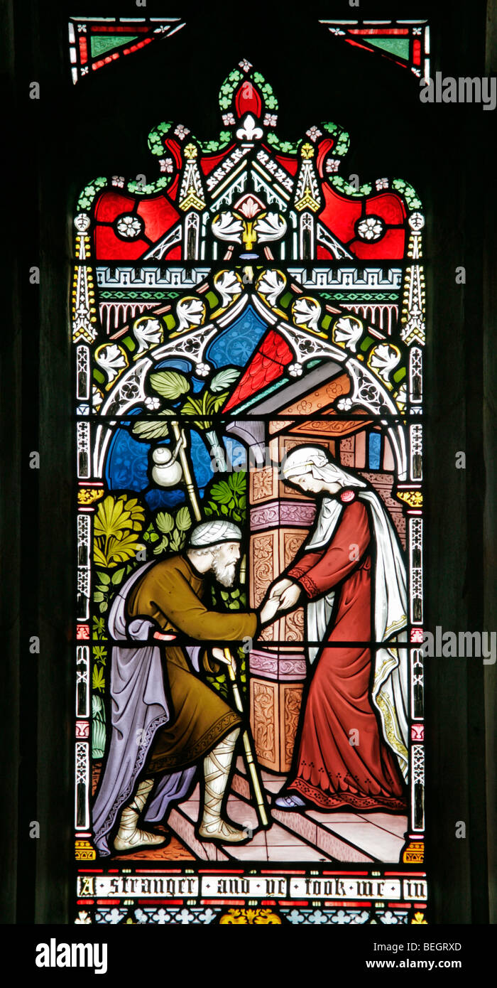 Ein Buntglasfenster, das einen korporalen Akt der Barmherzigkeit (Haus der Obdachlosen) von Frederick Preedy, Church of St Mary the Virgin, Gunthorpe, Norfolk darstellt Stockfoto