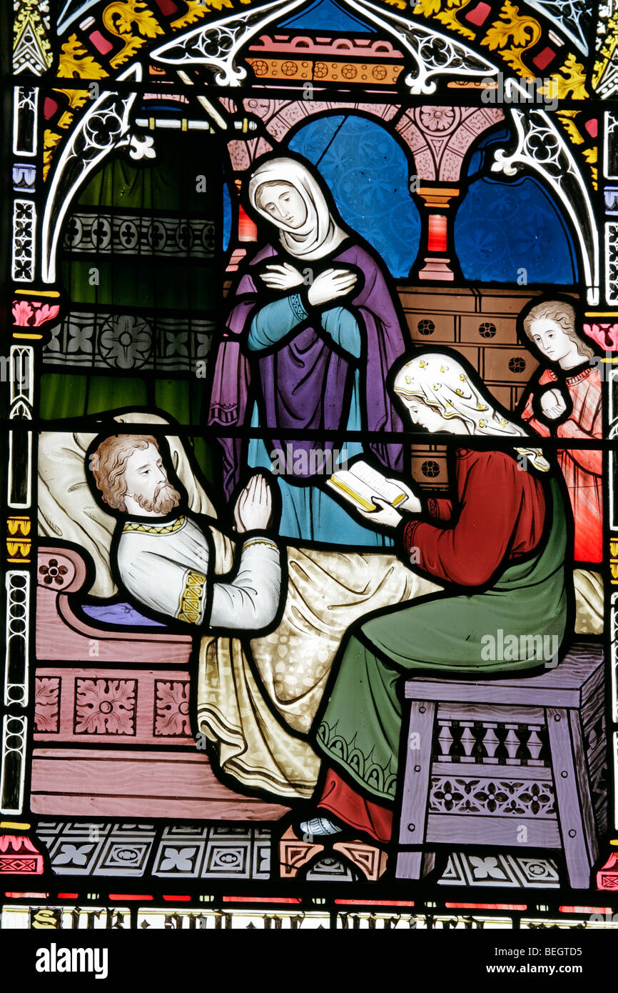 Detail eines Buntglasfensters, das einen korporalen Akt der Barmherzigkeit von Frederick Preedy, Church of St Mary the Virgin, Gunthorpe, Norfolk darstellt Stockfoto