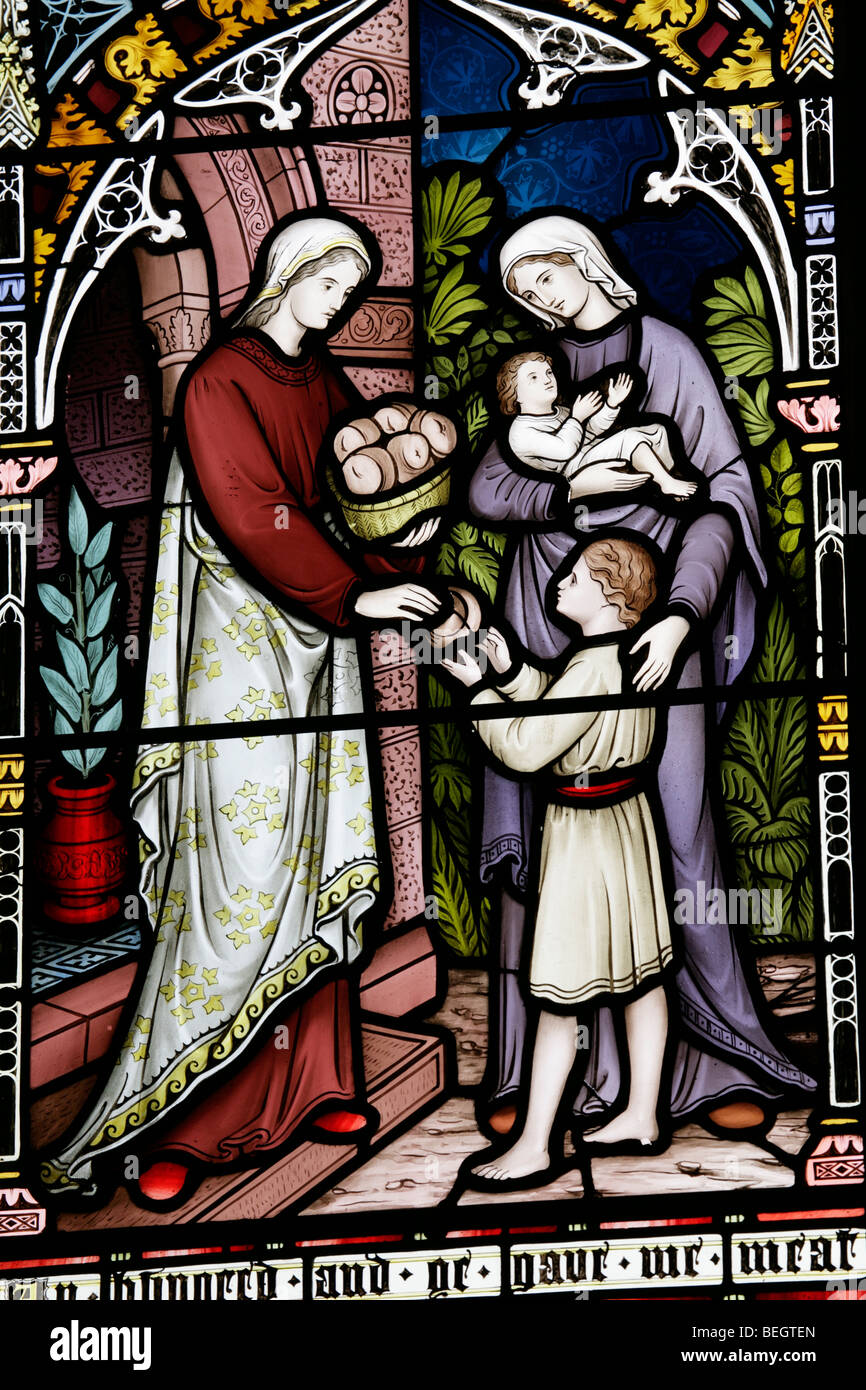 Ein Glasfenster von Frederick Preedy, das darstellt, ein korporaler Akt der Barmherzigkeit (füttern Sie die hungrigen), die Kirche der heiligen Jungfrau Maria, Gunthorpe, Norfolk Stockfoto
