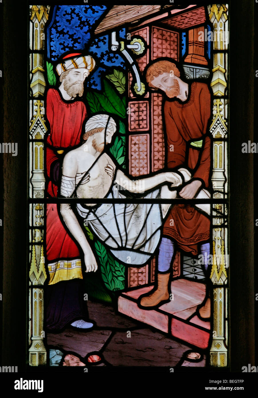 Ein Glasfenster von Frederick Preedy, das die Geschichte des Barmherzigen Samariters von Frederick Preedy, St Mary the Virgin, Gunthorpe, Norfolk darstellt Stockfoto