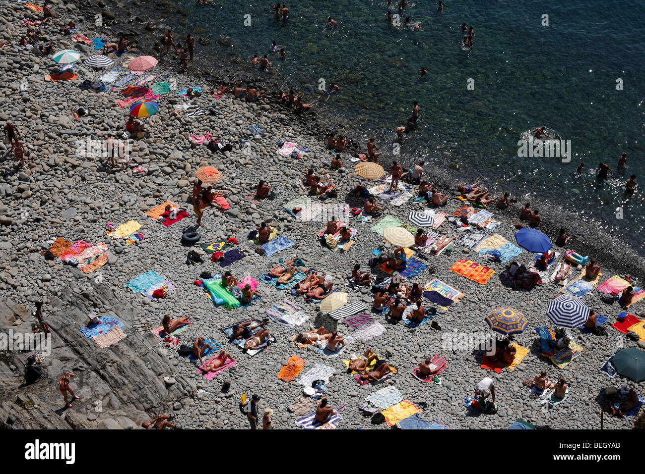 Sonnenanbeter am Strand von Riomaggiore in der Region Cinque Terre an der italienischen Riviera oder Riviera di Levanto Stockfoto