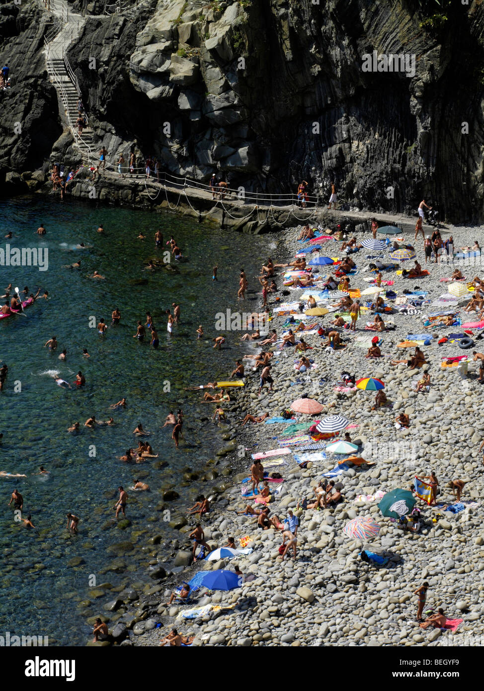 Sonnenanbeter am Strand von Riomaggiore in der Region Cinque Terre an der italienischen Riviera oder Riviera di Levanto Stockfoto