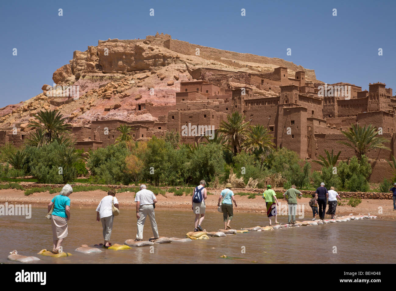 Touristen, die Überquerung des Flusses in Ait Ben Haddou Kasbah Ouarzazate Marokko Stockfoto