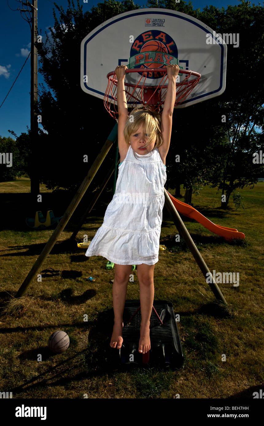 Kleinkind hängen vom Korb mit Basketballfeld Stockfoto
