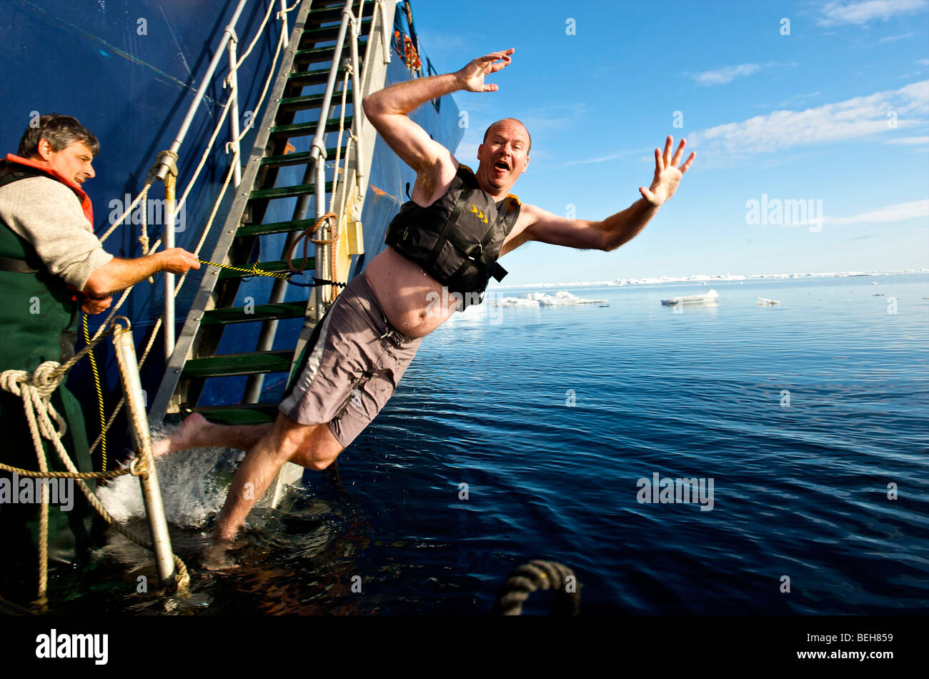 Passagiere der Akademik Shokalskiy nehmen eine arktische Sprung Stockfoto