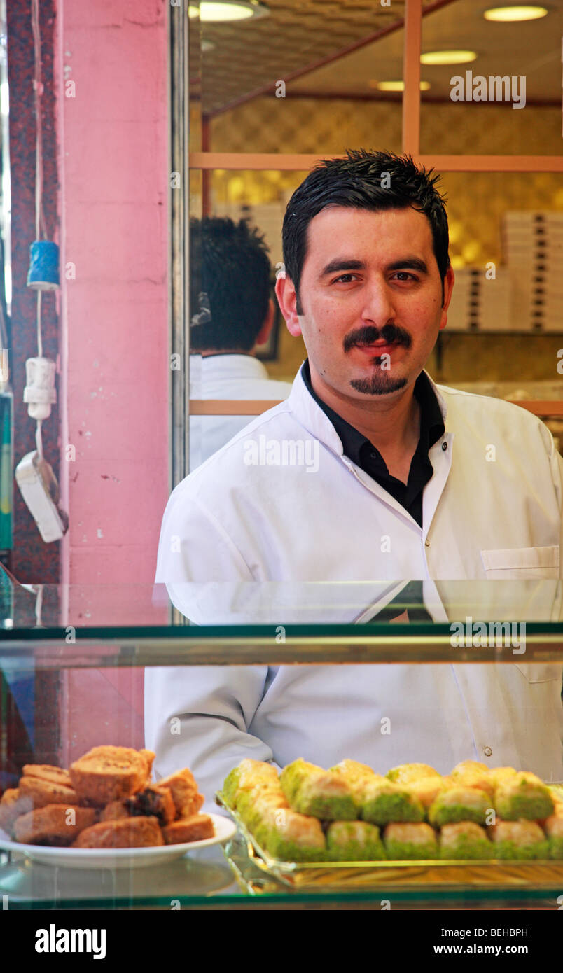 Türkischer Mann Baklava und anderen Süßigkeiten und Gebäck in einem Geschäft zu verkaufen. Das Basar-Viertel, Istanbul, Türkei Stockfoto