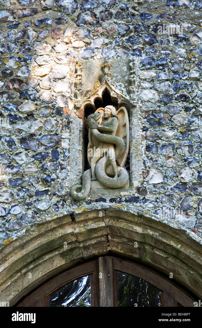 Statue des Heiligen Michael kämpfen eine Schlange über den Süden Veranda Eingang zur Irstead Kirche, Norfolk, England, Vereinigtes Königreich. Stockfoto