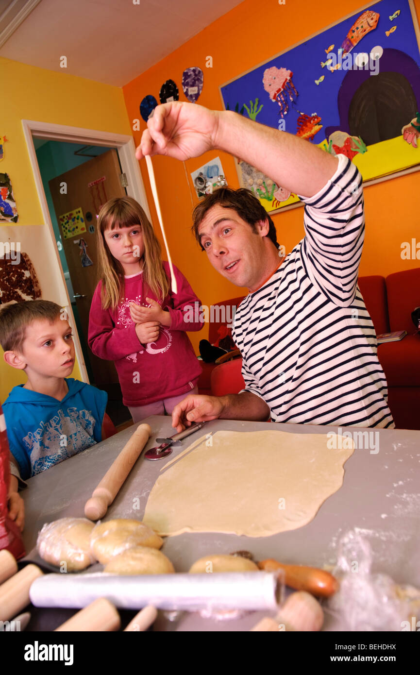 Essen Erzieher zeigen junge Kinder wie man frische Eiernudeln und lernen, wie man Essen und kochen, gesunde Ernährung, Wales UK Stockfoto