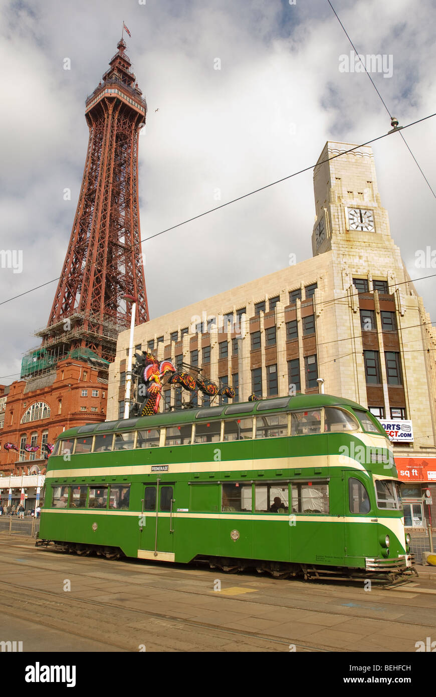 Blackpool Tower mit einem der berühmten grünen Trams, die entlang der Strandpromenade laufen. Stockfoto