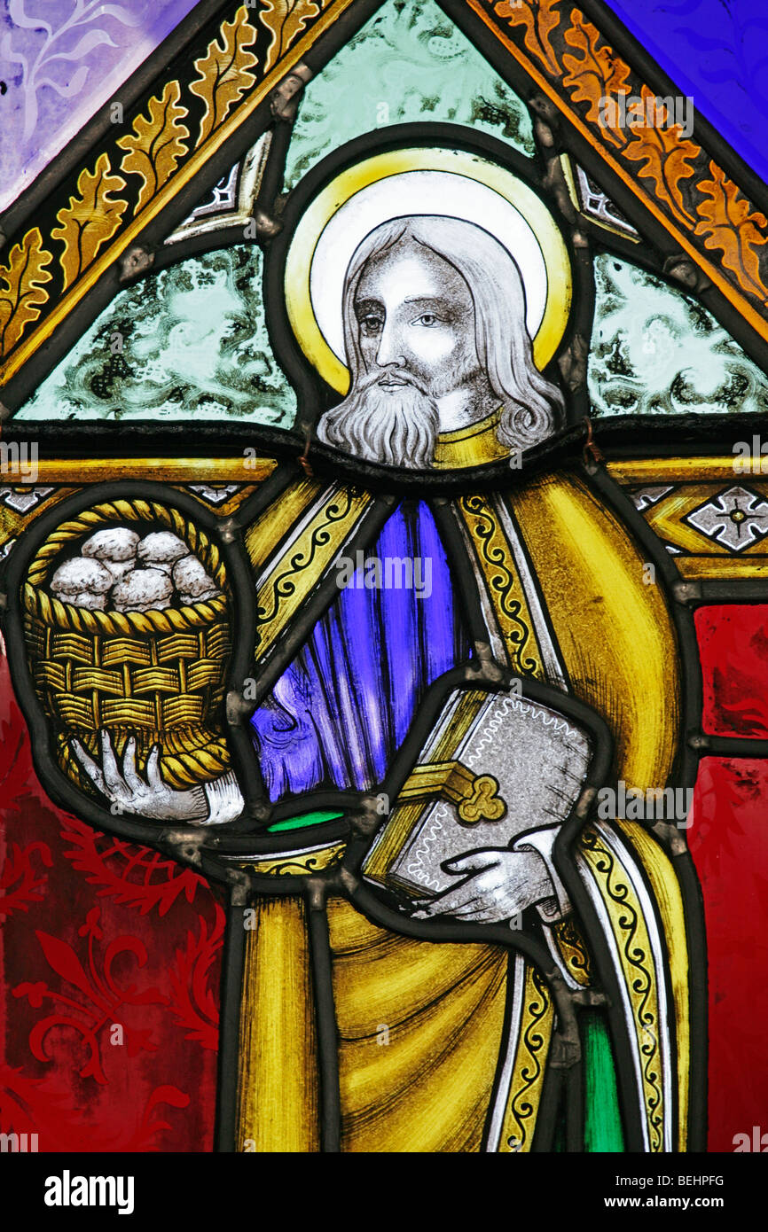Ein Buntglasfenster von Joseph Grant von Costessey, das den heiligen Philipp den Apostel darstellt, der einen Korb mit Broten hält, die Allerheiligenkirche, Wighton, Norfolk Stockfoto