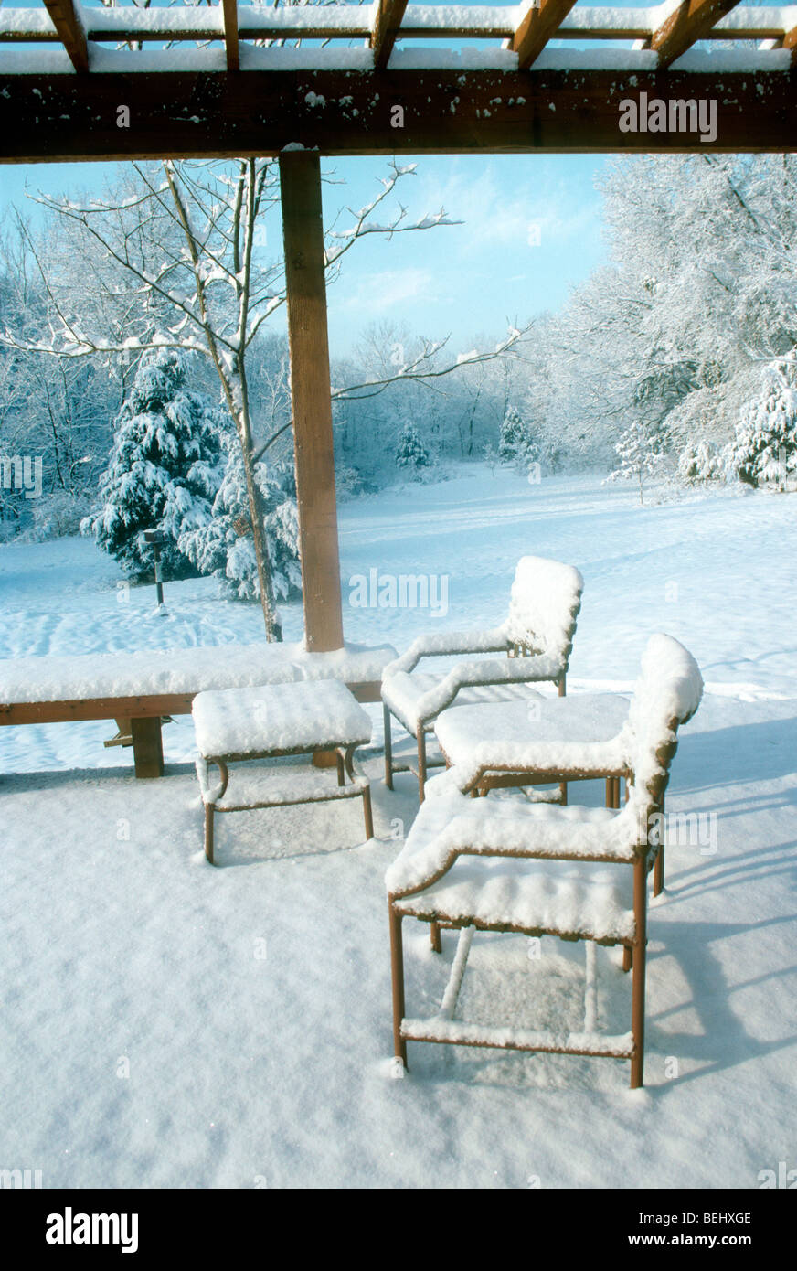 Neue Schnee auf Deck und Gartenmöbel im Winter Morgenlicht leuchtende besdie das Haus, Midwest USA Stockfoto
