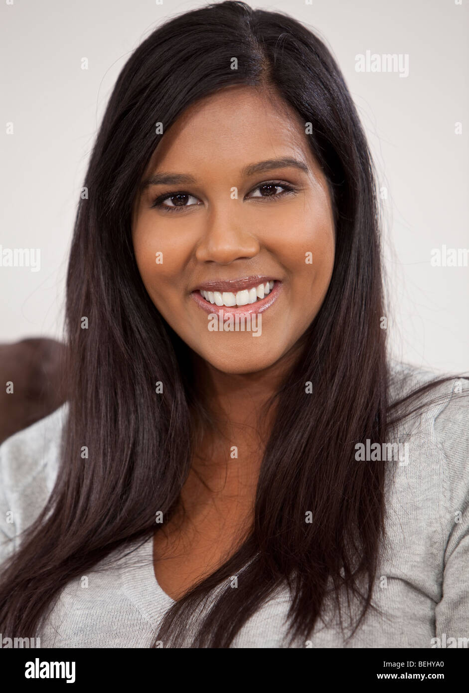 Eine schöne junge indische asiatische Frau mit einem perfekten toothy Lächeln. Stockfoto