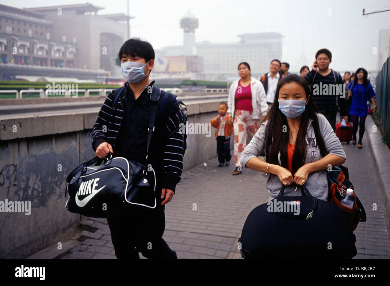 Ein Mann und eine Frau tragen Masken zum Schutz gegen schwere Luftverschmutzung in Peking, China. 30 Sep 2009 Stockfoto