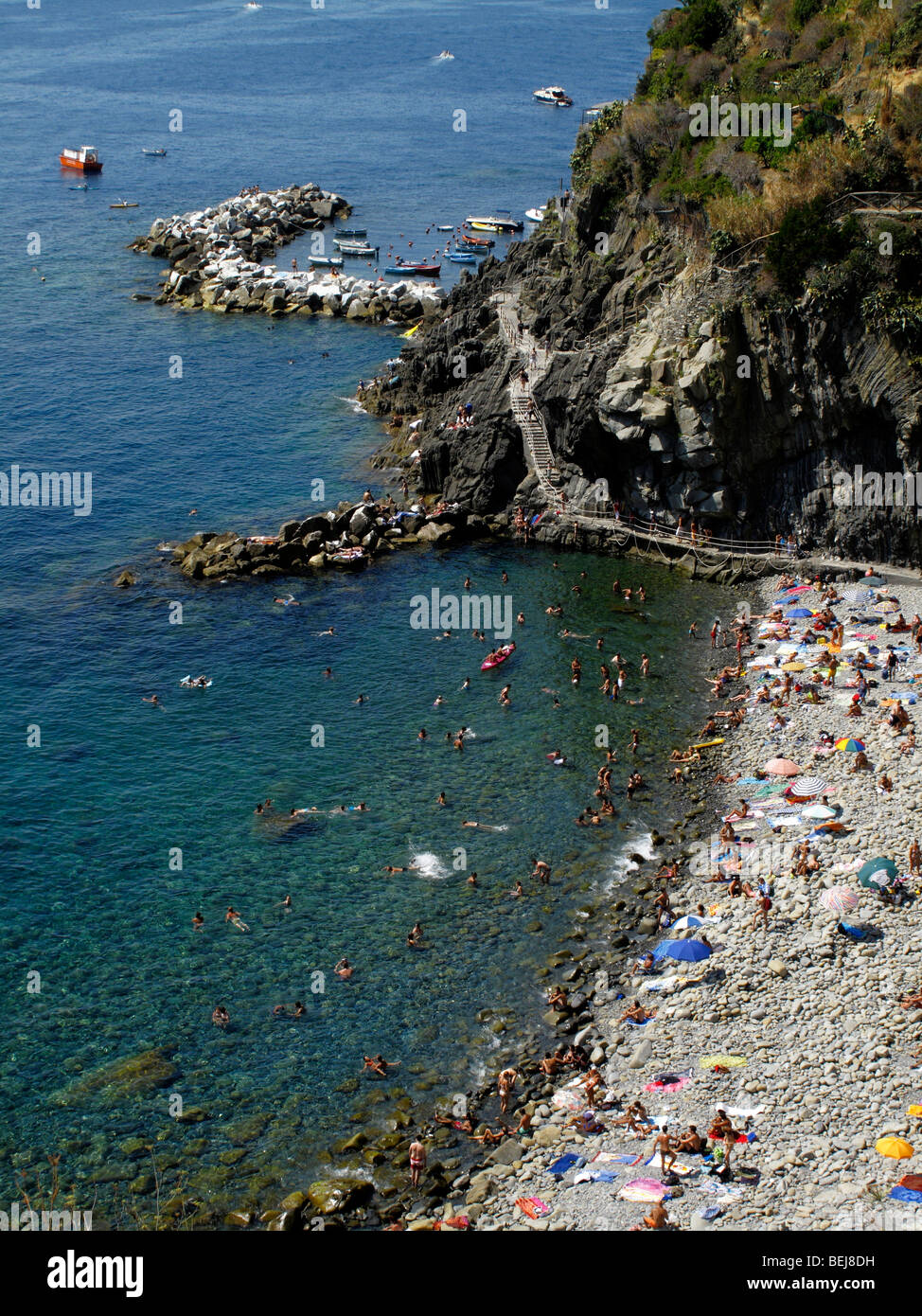Sonnenanbeter am Strand von Riomaggiore in der Region Cinque Terre an der italienischen Riviera oder Riviera di Levanto Stockfoto