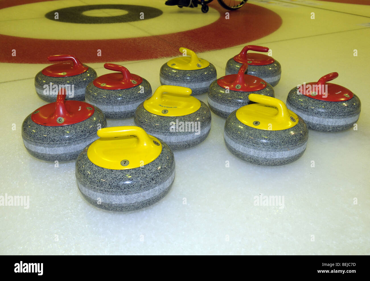 Gelb und rot Curling Steinen auf dem Eis. Stockfoto