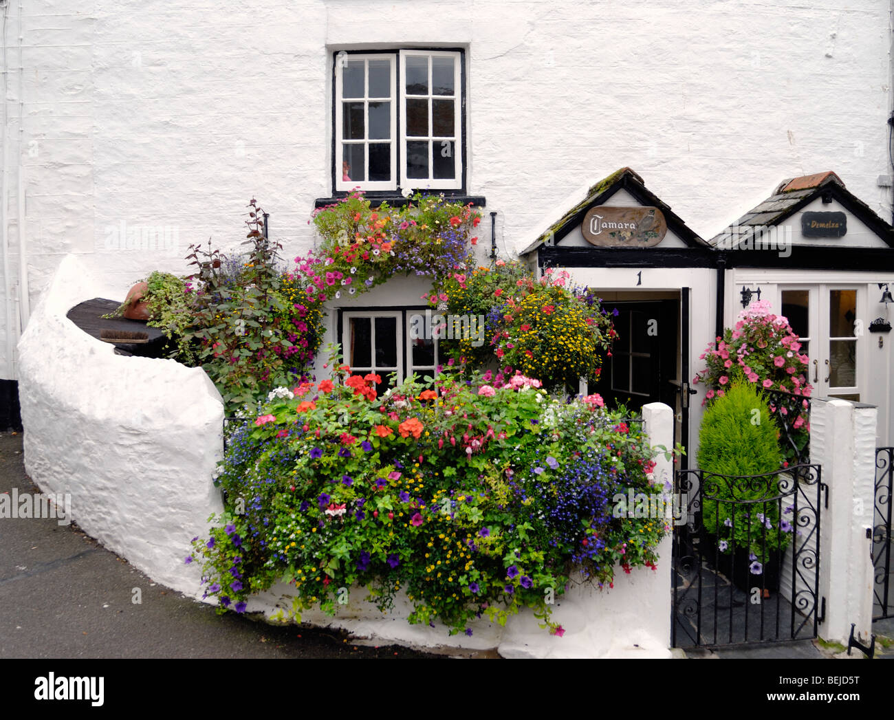 Eine alte weiß gestrichenen Haus mit einem Garten voller Blumen in voller Blüte Stockfoto