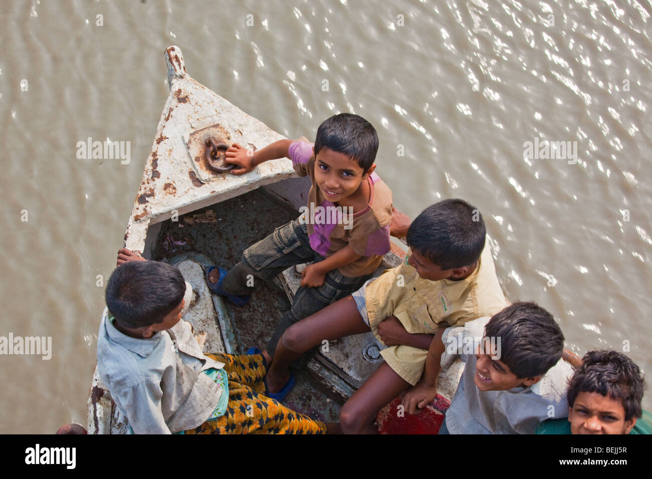 Jungs auf der Vorderseite des Rocket-Paddelboot am Fluss Brahmaputra in Bangladesch Stockfoto